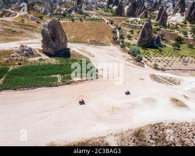 Vue aérienne du parc national de Goreme, Tarihi Milli Parki, Turquie. Les formations rocheuses typiques de Cappadoce. Touristes sur les quads Banque D'Images