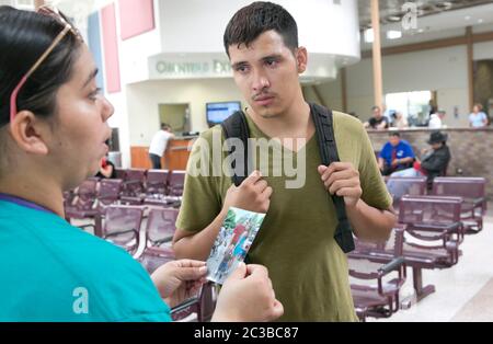 McAllen Texas USA, 24 juin 2014: JULIO Cesar Garcia Duarte, CITOYEN AMÉRICAIN, montre avec force une photo de sa famille lorsqu'il parle avec des bénévoles et des employés de la gare routière de McAllen, Texas, pour essayer d'obtenir des informations sur son épouse de fait guatémaltèque et son enfant qu'il tente de localiser. Il avait l'information qu'ils traversaient la frontière entre le Mexique et les États-Unis ce jour-là avec un « coyote ». ©Marjorie Kamys Cotera/Daemmrich Photographie Banque D'Images