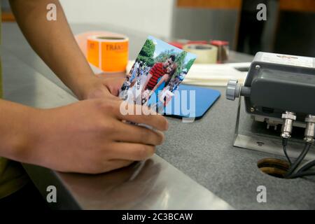 McAllen Texas USA, 24 juin 2014: JULIO Cesar Garcia Duarte, CITOYEN AMÉRICAIN, montre avec force une photo de sa famille lorsqu'il parle avec des bénévoles et des employés de la gare routière de McAllen, Texas, pour essayer d'obtenir des informations sur son épouse de fait guatémaltèque et son enfant qu'il tente de localiser. Il avait l'information qu'ils traversaient la frontière entre le Mexique et les États-Unis ce jour-là avec un « coyote ». ©Marjorie Kamys Cotera/Daemmrich Photographie Banque D'Images