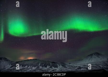 Vue incroyable sur aurora borealis, lumière verte magique illuminant dans le ciel nocturne, forces de la nature, merveilleux paysage islandais Banque D'Images