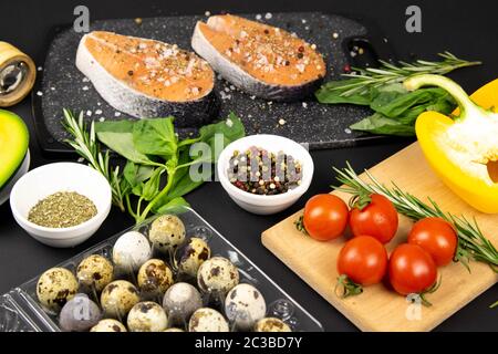 Un ensemble de nourriture saine et équilibrée, saumon frais, légumes, céréales sur fond noir Banque D'Images