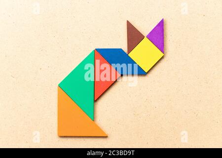 Casse-tête tangram couleur en forme de chat assis sur fond de bois Banque D'Images