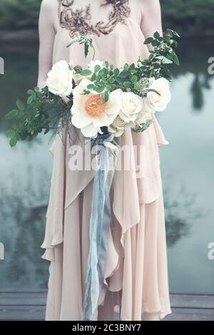 Femme en robe boho avec bouquet luxuriant Banque D'Images