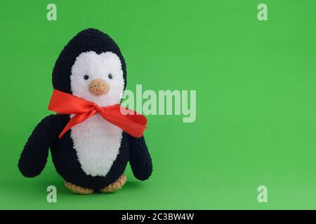Pingouin en peluche tricoté sur fond vert Banque D'Images