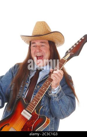 Un bel homme autochtone dans une veste de jeans et un chapeau de cowboy et permanent à jouer de la guitare, isolée pour fond blanc Banque D'Images