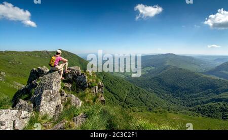 Randonneur surplombant les montagnes du Cantal, Parc naturel régional des volcans d'Auvergne, Cantal, Auvergne-Rhône-Alpes, France Banque D'Images