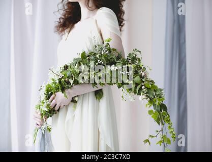 Mariée dans une robe délicate avec bouquet de petites fleurs blanches Banque D'Images