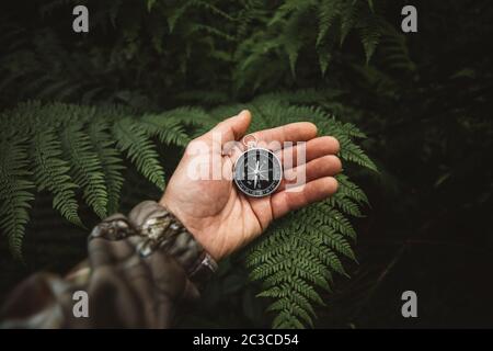 Explorer personnes tenant une boussole et recherchant les bonnes directions dans la jungle.Survival Voyage, concept de style de vie. Banque D'Images