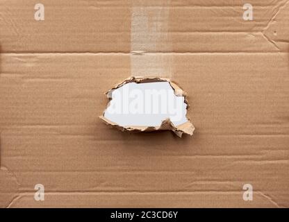 trou dans du papier en carton marron avec bords déchirés et incurvés. Modèle vide. Banque D'Images