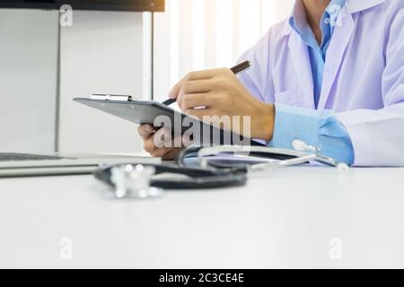 Le médecin travaille avec un stylo écrit remplit sur le dossier médical des patients dossier de santé papier vierge formulaire de rapport médical Banque D'Images
