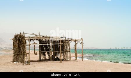 cabane de palmiers avec des ordures sur les rives de la mer Rouge en Egypte Dahab Banque D'Images