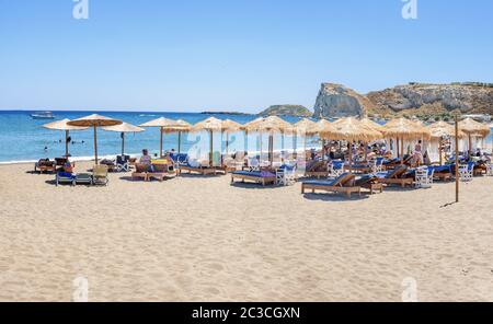 Location de vacances, chaises longues et parasols sur la plage de Stegna (RHODES, GRÈCE) Banque D'Images