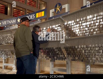 Austin Texas USA, mai 2013: Des vétérans militaires hispaniques de sexe masculin visitent le musée LBJ, où des copies des « étiquettes » d'identification des États-Unis des membres des forces armées américaines pendant la guerre du Vietnam étaient exposées. ©Marjorie Kamys Cotera/Daemmrich Photographie Banque D'Images