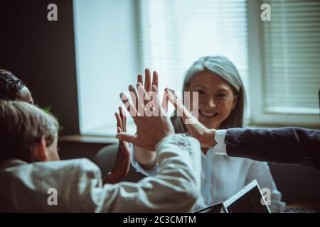 Cinq gestes importants du personnel de bureau après un brainstorming réussi. Concept de renforcement d'équipe. Attention sélective aux mains humaines. Gros plan. Image teintée Banque D'Images