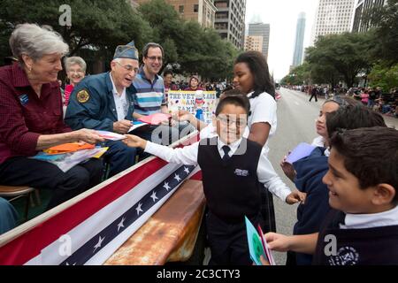 11 novembre 2015, Austin, Texas États-Unis : les enfants d'âge scolaire donnent des cartes faites main aux anciens combattants militaires lors du défilé annuel de la fête des anciens combattants sur l'avenue du Congrès. ©Marjorie Kamys Cotera/Daemmrich Photographie Banque D'Images