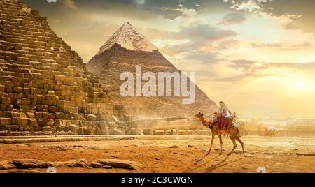 Nomad sur camel près de pyramides dans le désert égyptien Banque D'Images