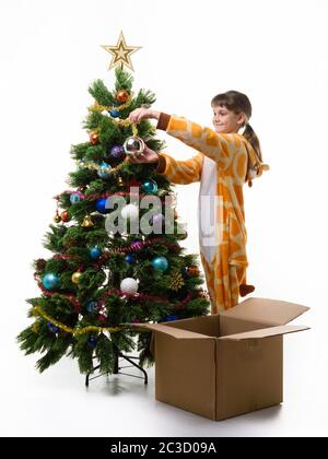 Une fille de neuf ans avec un sourire habille l'arbre de Noël Banque D'Images