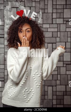 Gros plan Portrait d'une jeune fille afro-américaine aux cheveux bouclés dans un chandail blanc Banque D'Images