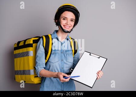 Portrait positive fille courier tenir le tableau à pince livrer sushi snack déjeuner demander au client mettre signature papier blanc porter sac à dos thermique porter jeans denim Banque D'Images