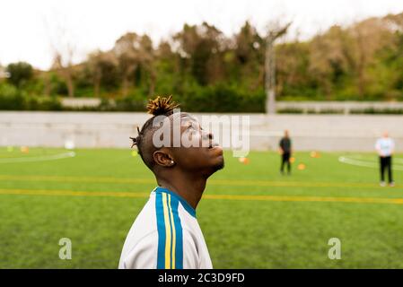 Barcelone, espagne - 10 juin 2020 : Portrait d'un jeune homme immigrant noir africain jouant au football en équipe, souriant et appréciant ensemble avec ses coéquipiers Banque D'Images