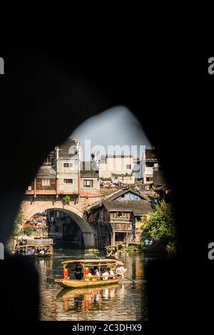 Touristes dans le vieux bateau en bois à Fenghuang Banque D'Images