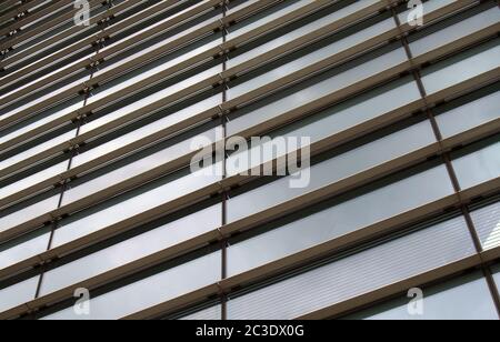 vue verticale en perspective de la façade d'un bâtiment commercial moderne en verre avec des cadres en acier et le ciel reflété dans les fenêtres Banque D'Images