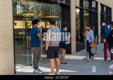 Clients et travailleurs à l'extérieur de la nouvelle boutique Apple, dans le quartier de Meatpacking à New York, le jeudi 18 juin 2020. Les magasins ont un personnel de nettoyage dédié et sont approvisionnés en masques, assainisseurs et iPhones, (© Richard B. Levine) Banque D'Images