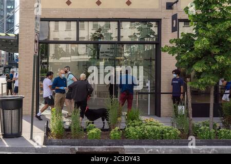 Clients et travailleurs à l'extérieur de la nouvelle boutique Apple, dans le quartier de Meatpacking à New York, le jeudi 18 juin 2020. Les magasins ont un personnel de nettoyage dédié et sont approvisionnés en masques, assainisseurs et iPhones, (© Richard B. Levine) Banque D'Images