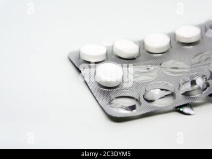 pilules blanches emballées dans une plaquette en aluminium et en plastique avec quelques pilules manquantes déjà utilisées. Pharmace