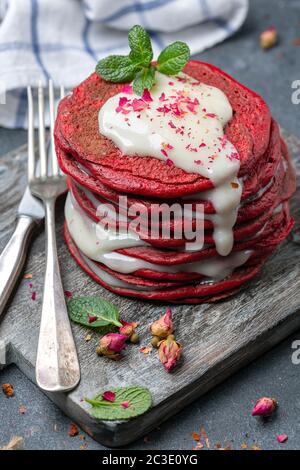 Crêpes en velours rouge servies avec une sauce au fromage à la crème. Banque D'Images