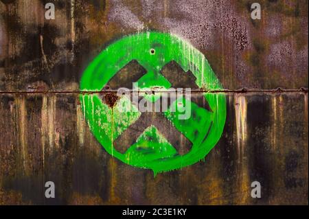 Marteau croisé et picher comme symbole de l'exploitation minière - pictogramme vert peint sur un mur de grunge sombre et rouillé plein de taches Banque D'Images