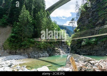 Rania, GR / Suisse- 13 juin 2020: Randonnée en famille à travers un pont suspendu en bois sur le Rhin dans la gorge de Viamala dans les Alpes SWIS Banque D'Images