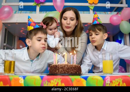 Family blowing candles on cake Banque D'Images