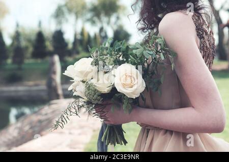 Femme en robe boho avec bouquet luxuriant Banque D'Images