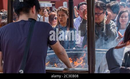 Tourisme tirant de la fumée (croyez avoir des propriétés de guérison) de Jokoro ou brûleur d'encens à eux-mêmes au Temple Sensoji à Tokyo, Japon. Banque D'Images