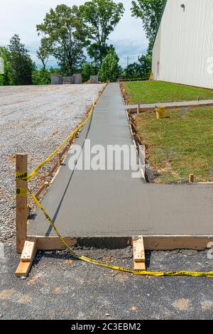 Plan vertical d'un trottoir en béton fraîchement coulé sur un chantier de construction. Banque D'Images