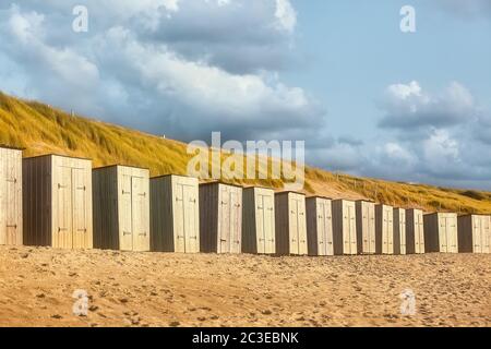 Cabines de plage sur la plage de sable en face des dunes Banque D'Images