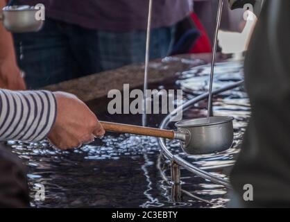 Les touristes se purifient d'eau avant d'entrer dans le temple Sensoji, Tokyo, Japon Banque D'Images