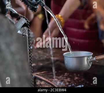 Les touristes se purifient d'eau avant d'entrer dans le temple Sensoji, Tokyo, Japon Banque D'Images