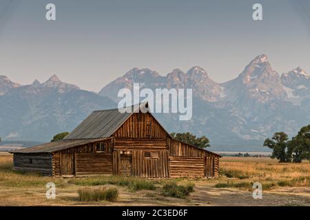 Lever du matin au-dessus de la grange T.A Molton dans le quartier historique de Mormon Row, le long des Flats d'Antelope, avec les montagnes de Grand Teton derrière au parc national de Grand Teton, Wyoming. Banque D'Images