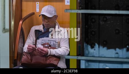 Homme avec smartphone assis dans la ligne de métro Ginza de Tokyo, Tokyo, Japon Banque D'Images