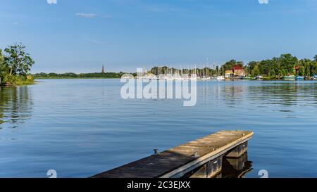 Bateaux à moteur et à voile ancrés sur le lac lagon ou quai avec roseaux et essais de rivière verte Banque D'Images