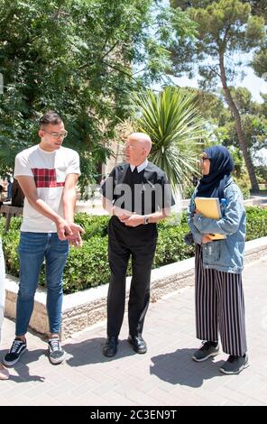 Le frère Peter Bray, vice-chancelier de l'Université de Bethléem, parle avec certains de ses étudiants sur le campus. Banque D'Images