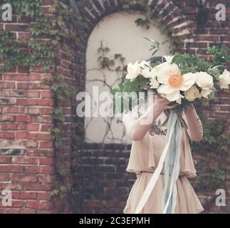 Femme en robe boho avec bouquet luxuriant Banque D'Images