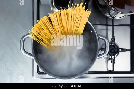 Cuisson de spaghetti crus dans l'eau bouillante contenue dans une casserole Banque D'Images