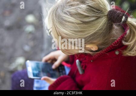 Fille (7) utilisant un smartphone, Kiel, Schleswig-Holstein, Allemagne Banque D'Images