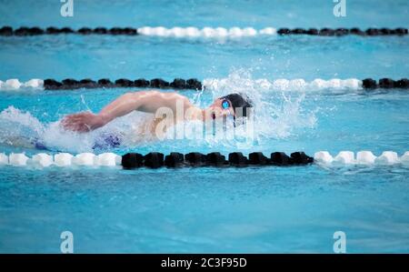 Un jeune nageur de natation naque librement dans une piscine pendant une compétition Banque D'Images