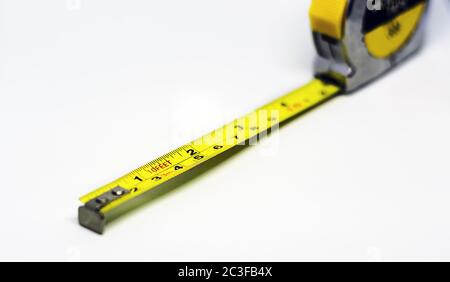 mètre-ruban métallique jaune rétractable. Mesures exprimées en centimètres et en pieds. Banque D'Images