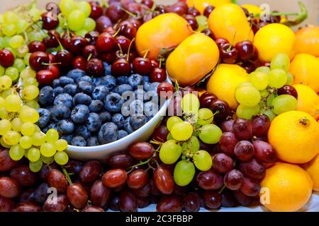 Fruits frais biologiques, bleuets, raisins rouges et verts et mandarines. Gros plan. Banque D'Images