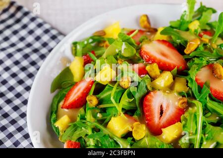 Salade verte avec arugula, fraises, mangue et pistaches. Banque D'Images